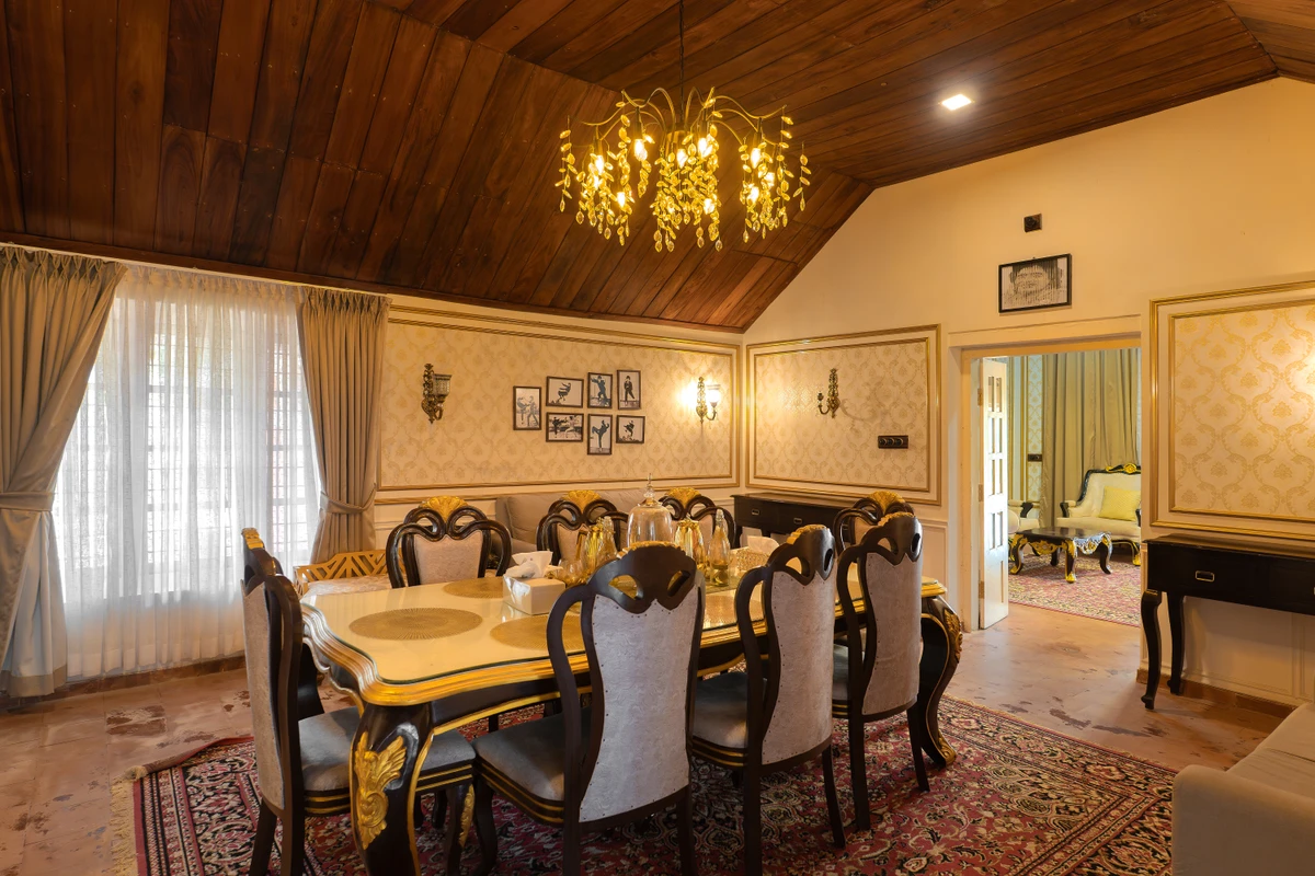 Luxury Dining Room with Chandelier Elegant dining room with a luxury glass table and chandelier at boCHE 1000 Acre, one of the best resorts in Wayanad.
