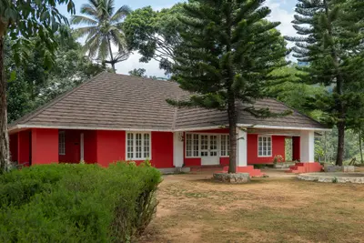 Wide angle view of british bungalow wayanad surrounded by tea plantation resort wayanad