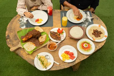 Authentic Kerala Outdoor Feast An authentic outdoor Kerala dining experience featuring a large spread of local delicacies at boCHE 1000 Acre resort in Wayanad.